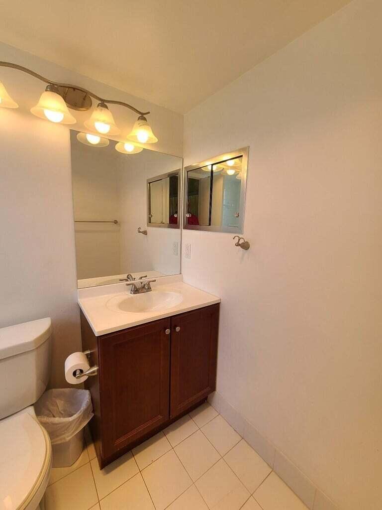 133 Camden East, Unit F West Palm Beach, FL 33417 - Photo 11 of 13 a bathroom with a sink mirror vanity and toilet