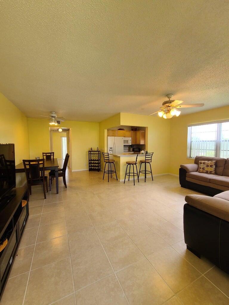 133 Camden East, Unit F West Palm Beach, FL 33417 - Photo 3 of 13 a living room with couches and kitchen view with wooden floor