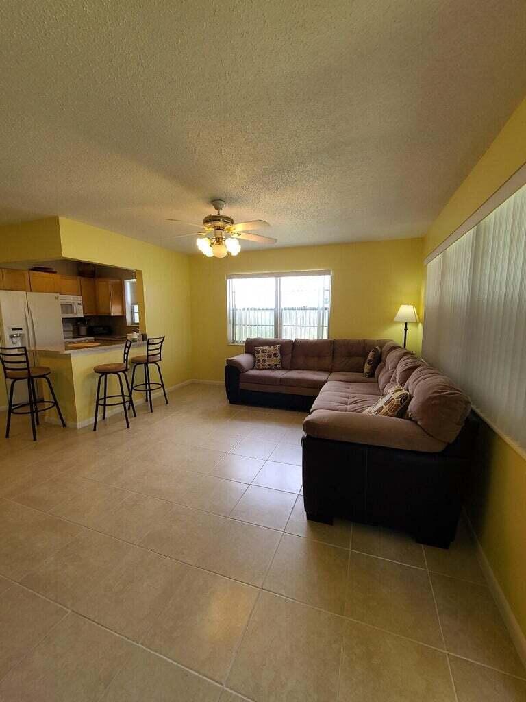 133 Camden East, Unit F West Palm Beach, FL 33417 - Photo 4 of 13 a living room with furniture and a flat screen tv