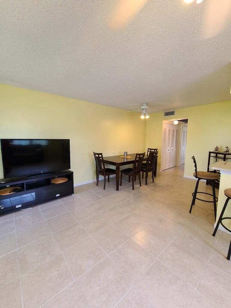 133 Camden East, Unit F West Palm Beach, FL 33417 - Photo 5 of 13 a view of a livingroom with furniture and a flat screen tv