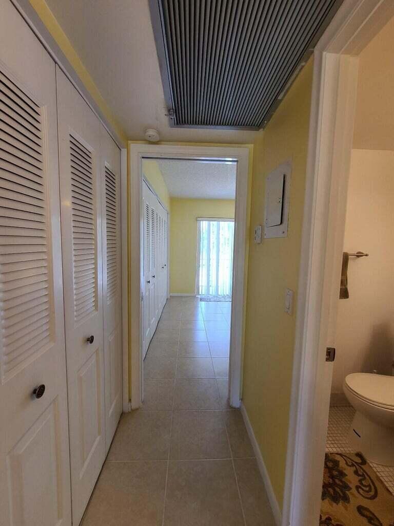 133 Camden East, Unit F West Palm Beach, FL 33417 - Photo 8 of 13 a view of a hallway with wooden floor and a bathroom