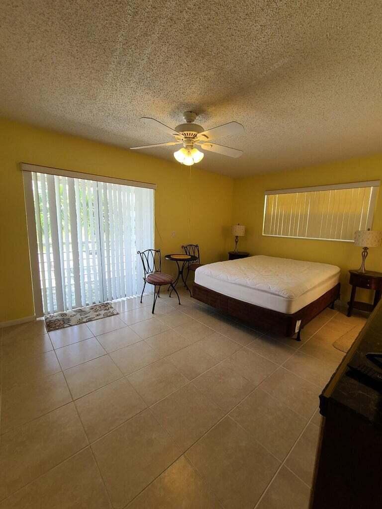 133 Camden East, Unit F West Palm Beach, FL 33417 - Photo 10 of 13 a bedroom with a bed and a chandelier