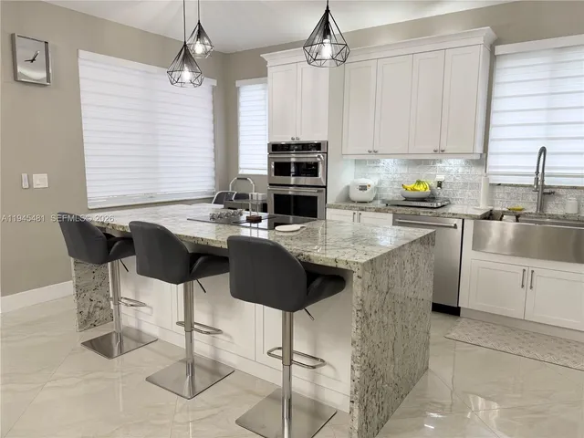 a kitchen with kitchen island a sink stove and refrigerator