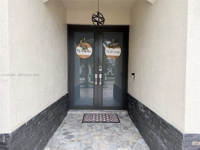 a view of a hallway to a livingroom with furniture and window