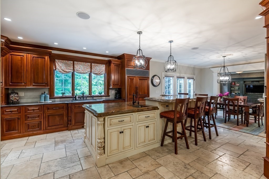 9 Prides Circle Andover, MA 01810 - Photo 11 of 42 a kitchen with granite countertop a stove a sink a dining table and chairs