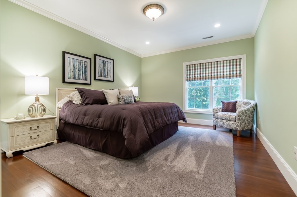 9 Prides Circle Andover, MA 01810 - Photo 33 of 42 a spacious bedroom with a large bed and a chandelier