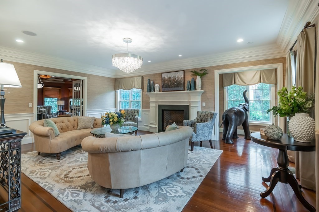 9 Prides Circle Andover, MA 01810 - Photo 6 of 42 a living room with furniture a fireplace a potted plant and a large window