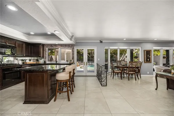 a kitchen with sink a refrigerator and chairs