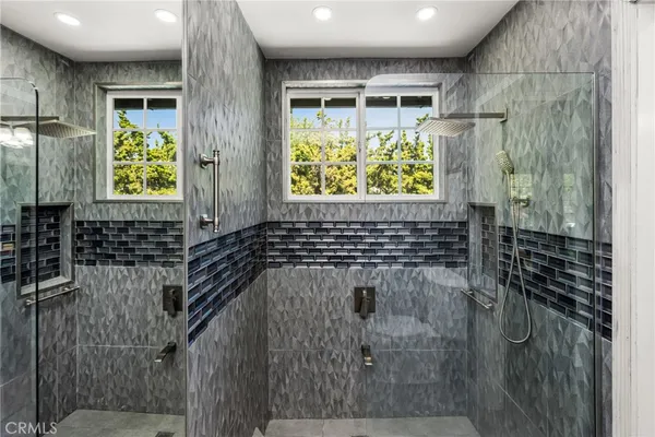 a kitchen with stainless steel appliances granite countertop a refrigerator a sink dishwasher a stove a dining table and chairs with wooden floor