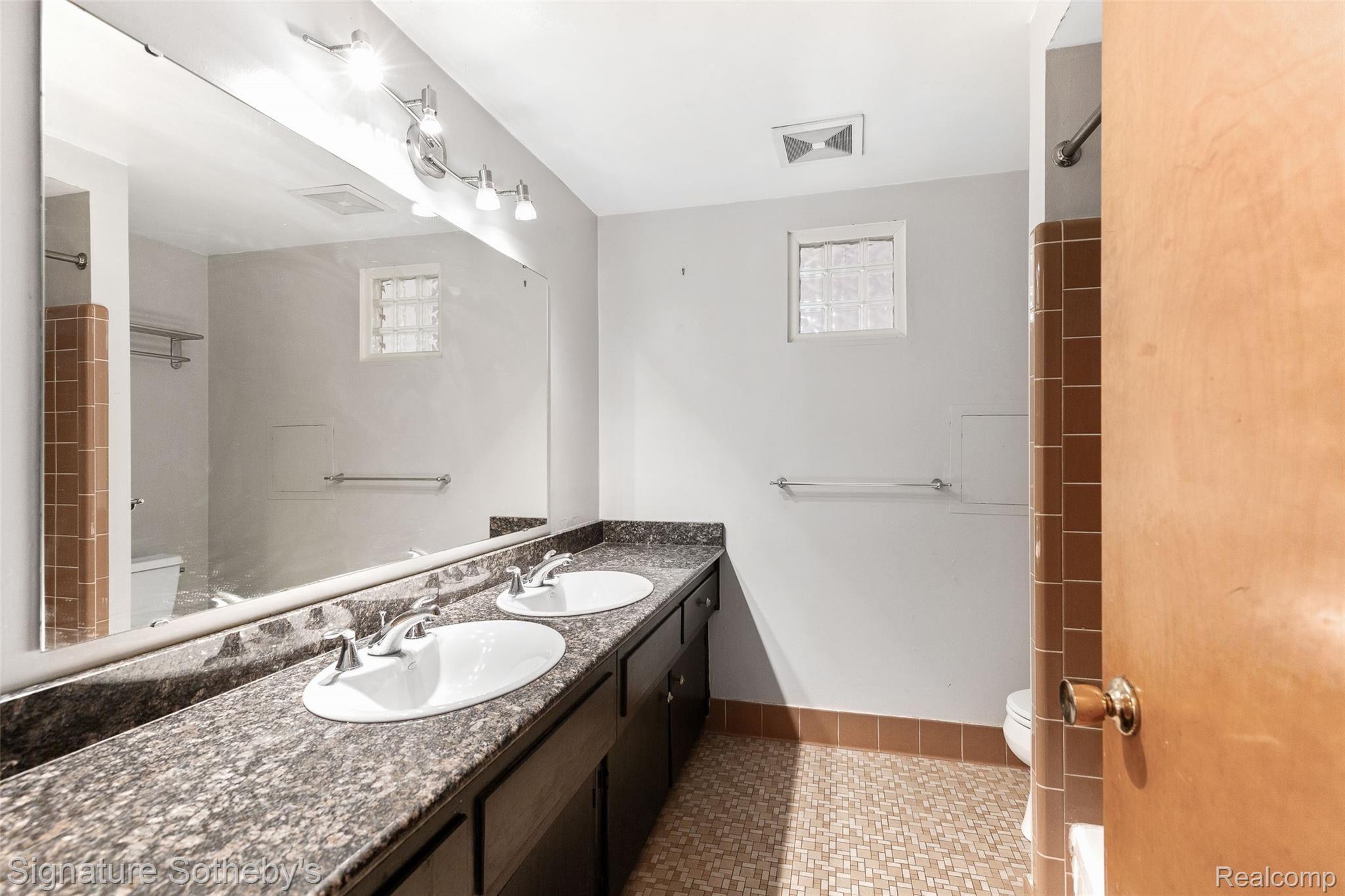 26269 Middlebelt Road Farmington, MI 48334 - Photo 16 of 32 Main bathroom on 2nd floor, note granite top, dual basins, updated lighting and glass block window