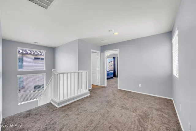 a spacious bedroom with a bed a couch and a ceiling fan