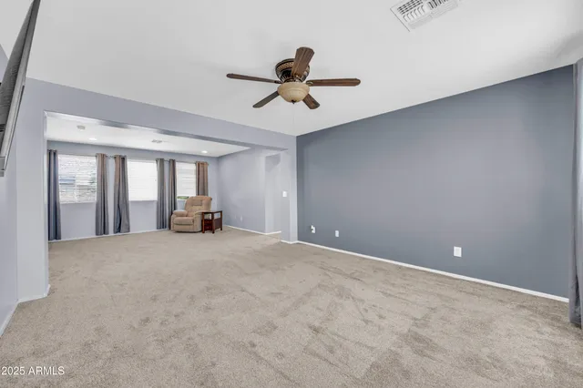 a view of an empty room with a ceiling fan