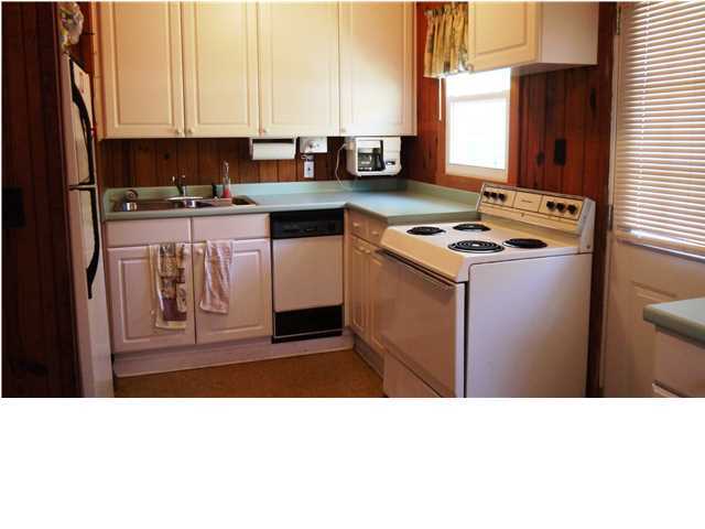 160 Pompano Street Inlet Beach, FL 32461 - Photo 5 of 11 a kitchen with kitchen island granite countertop a refrigerator stove top oven and sink