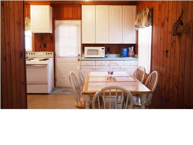160 Pompano Street Inlet Beach, FL 32461 - Photo 7 of 11 a kitchen with a table chairs refrigerator and cabinets