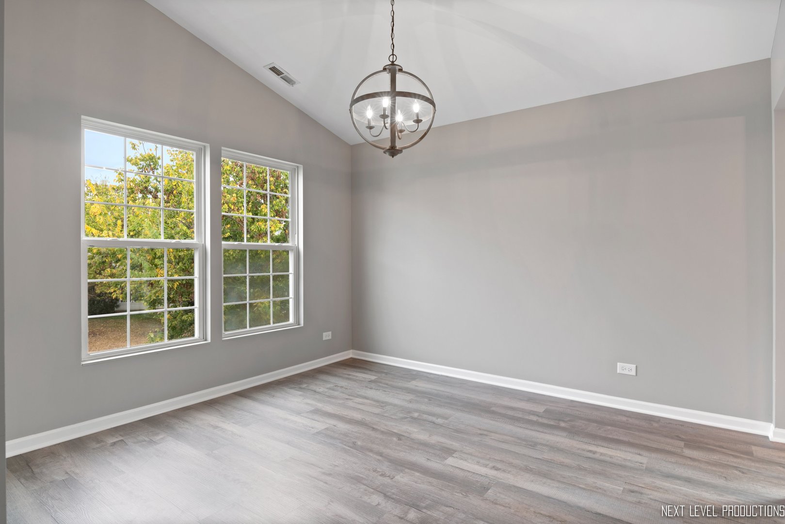 533 Metropolitan Street Aurora, IL 60502 - Photo 7 of 18 an empty room with wooden floor fan and windows