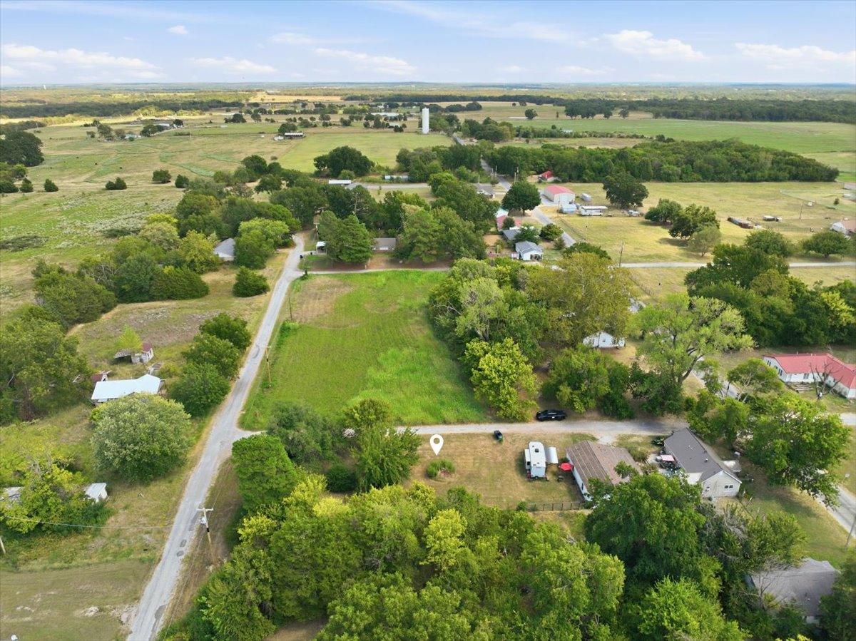 Expansive rural landscape featuring a mix of open fields, wooded areas, and scattered residential properties