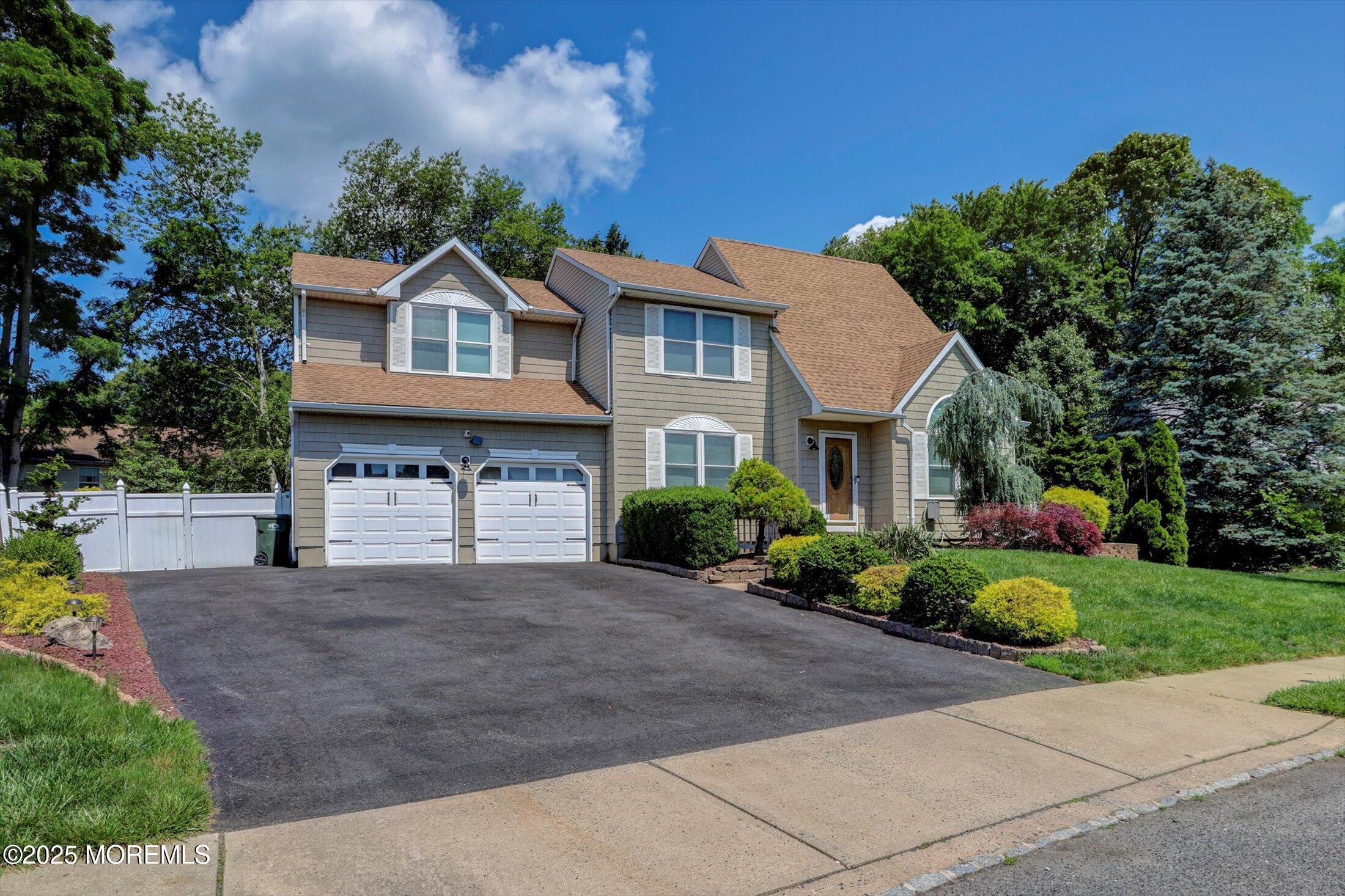 8 Shadow Ridge Court Howell, NJ 07731 - Photo 2 of 39 a front view of a house with a yard and garage