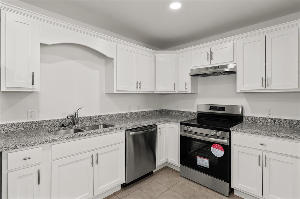 316 West 7th Street, Unit 104 Mount Pleasant, TX 75455 - Photo 3 of 13 a kitchen with granite countertop white cabinets and stainless steel appliances