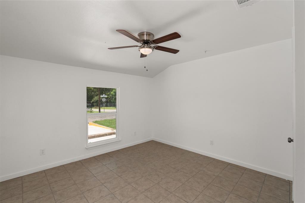 316 West 7th Street, Unit 104 Mount Pleasant, TX 75455 - Photo 5 of 13 an empty room with a window and a ceiling fan