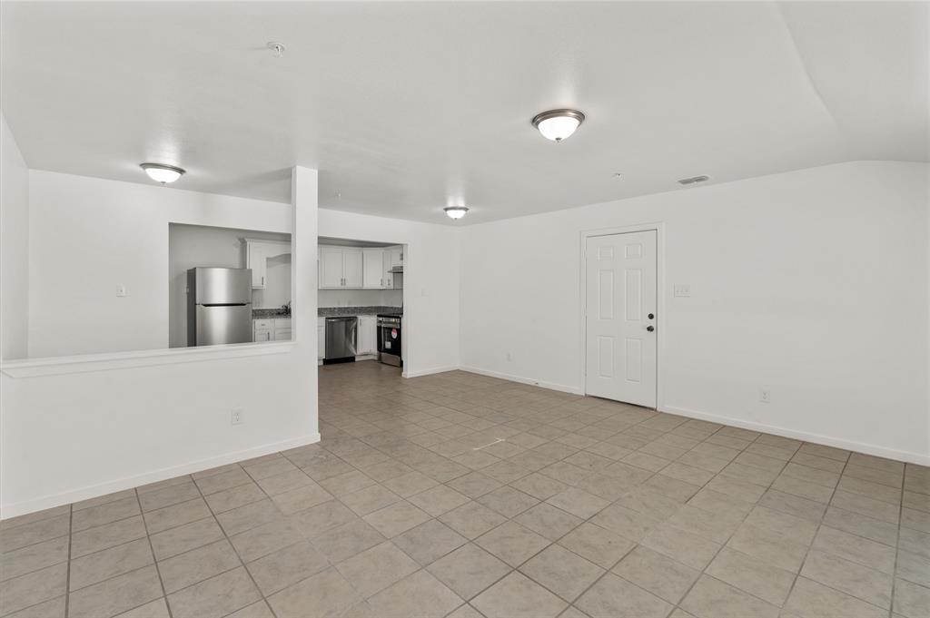 316 West 7th Street, Unit 104 Mount Pleasant, TX 75455 - Photo 8 of 13 a view of a kitchen with a sink and dishwasher a refrigerator with white cabinets