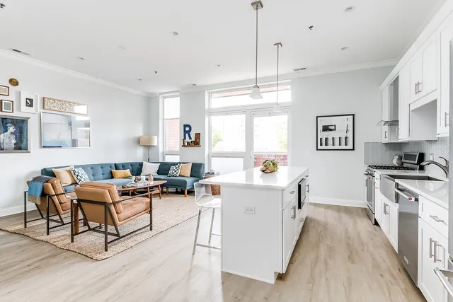 a living room with stainless steel appliances granite countertop furniture wooden floor and a view of kitchen