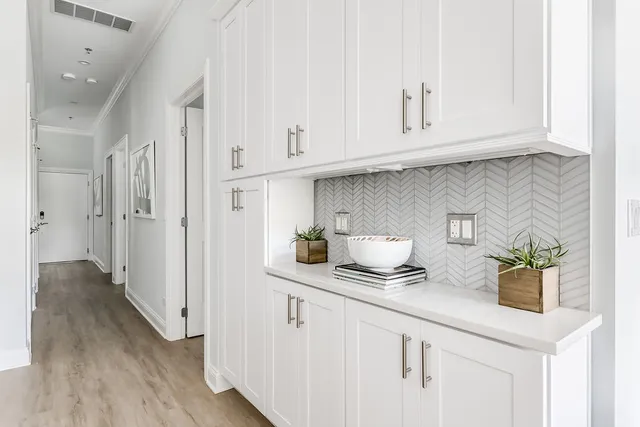 a kitchen with stainless steel appliances white cabinets and a wooden floor
