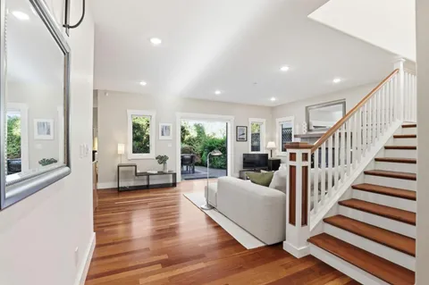 a living room with furniture and a large window with wooden floor