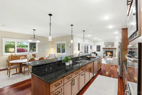 a kitchen with stove and a wooden floor