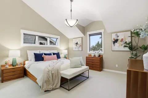 a bedroom with a bed chandelier and a window