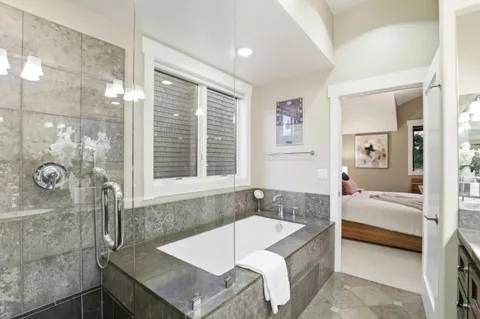a spacious bathroom with a tub sink and glass door