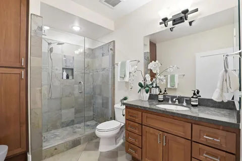 a bathroom with a sink a toilet and shower