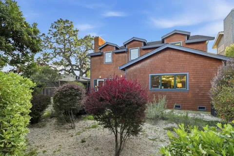 a view of a yard with plants and a fountain