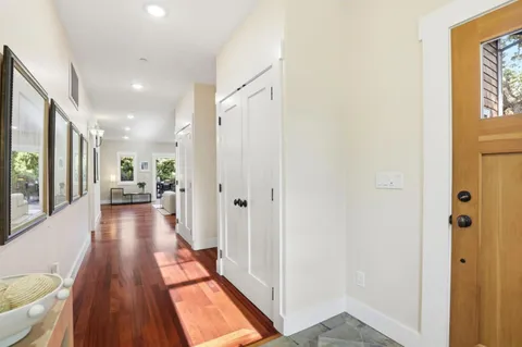 a view of a hallway with wooden floor and furniture
