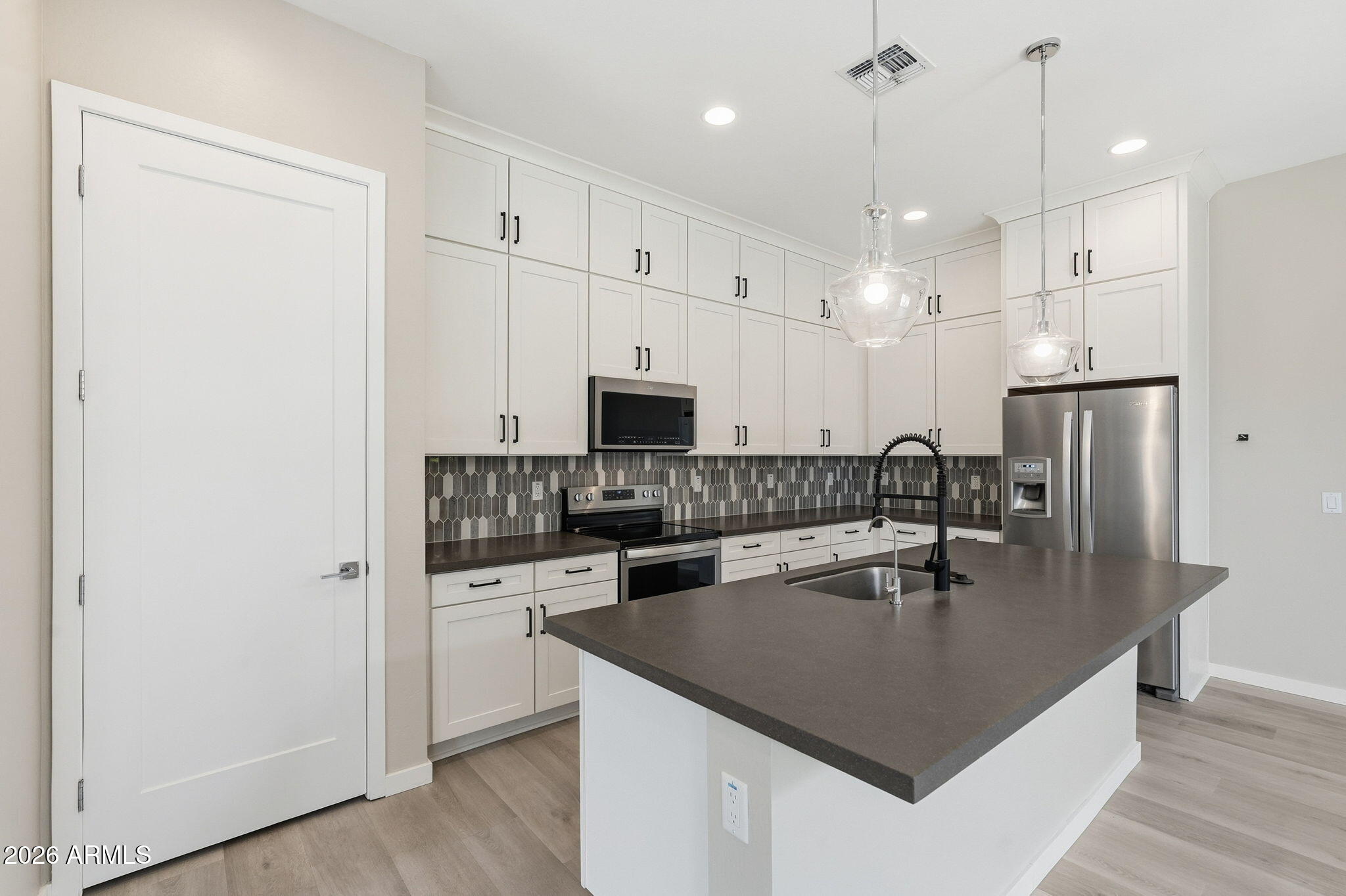 901 South Smith Road, Unit 1038 Tempe, AZ 85281 - Photo 10 of 29 a kitchen with stainless steel appliances granite countertop a sink a stove a refrigerator a center island with wooden floor and cabinets