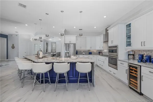 a kitchen with stainless steel appliances granite countertop a stove and white cabinets