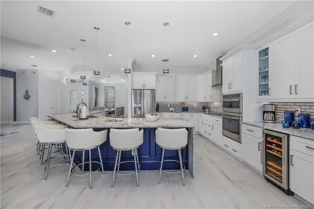 a kitchen with stainless steel appliances granite countertop a stove and white cabinets