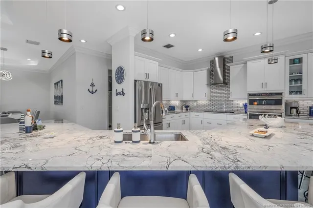 a large kitchen with kitchen island a dining table and chairs