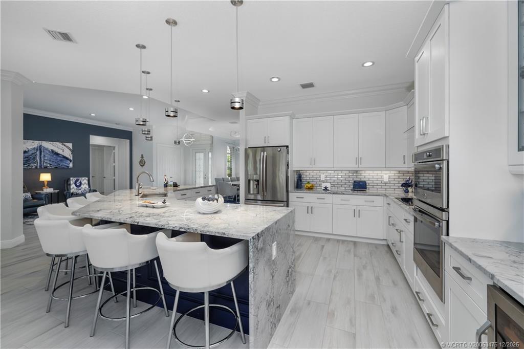 467 Southwest Lost River Road Stuart, FL 34997 - Photo 19 of 65 a large kitchen with kitchen island a dining table and chairs