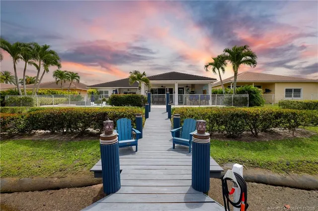 a front view of a house with a garden and trees