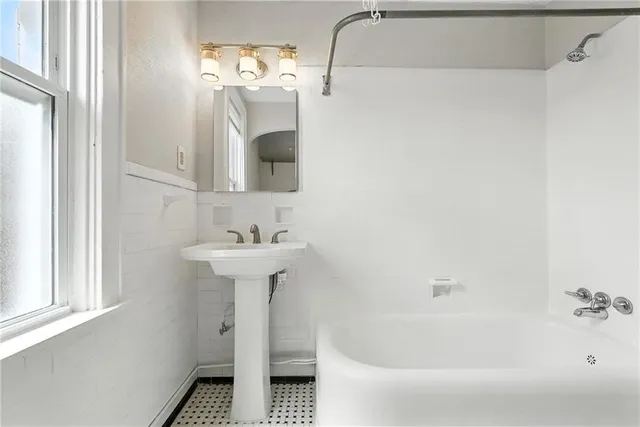 a bathroom with a sink a mirror and a bathtub