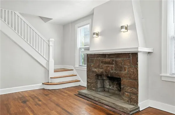a living room with wooden floor and a fireplace