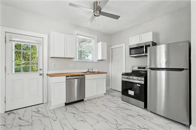 a kitchen with granite countertop a refrigerator and a sink
