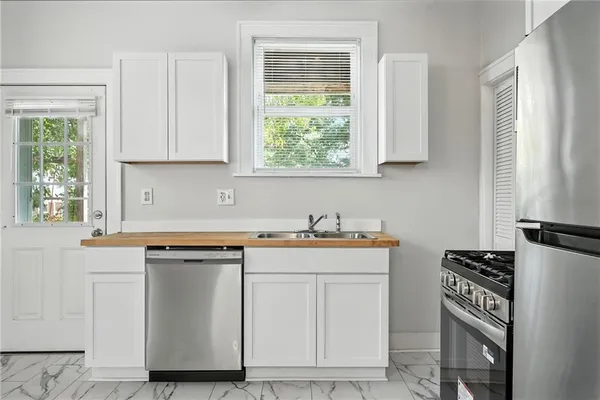 a kitchen with stainless steel appliances granite countertop a stove a sink and a microwave