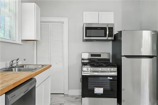 a kitchen with white cabinets and stainless steel appliances