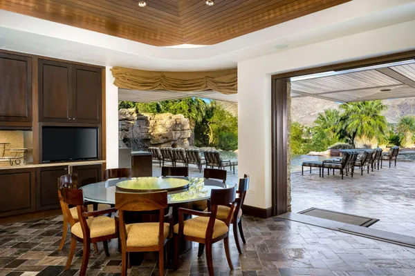 a living room with furniture a flat screen tv and a large window