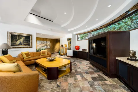 a spacious bedroom with a large bed and a flat tv screen