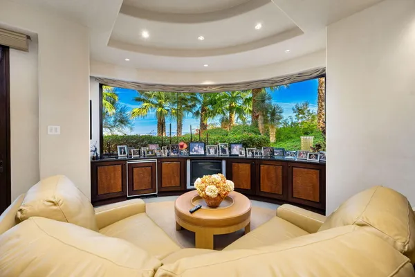 a view of a swimming pool with lawn chairs under an umbrella