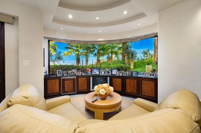 a view of a swimming pool with lawn chairs under an umbrella