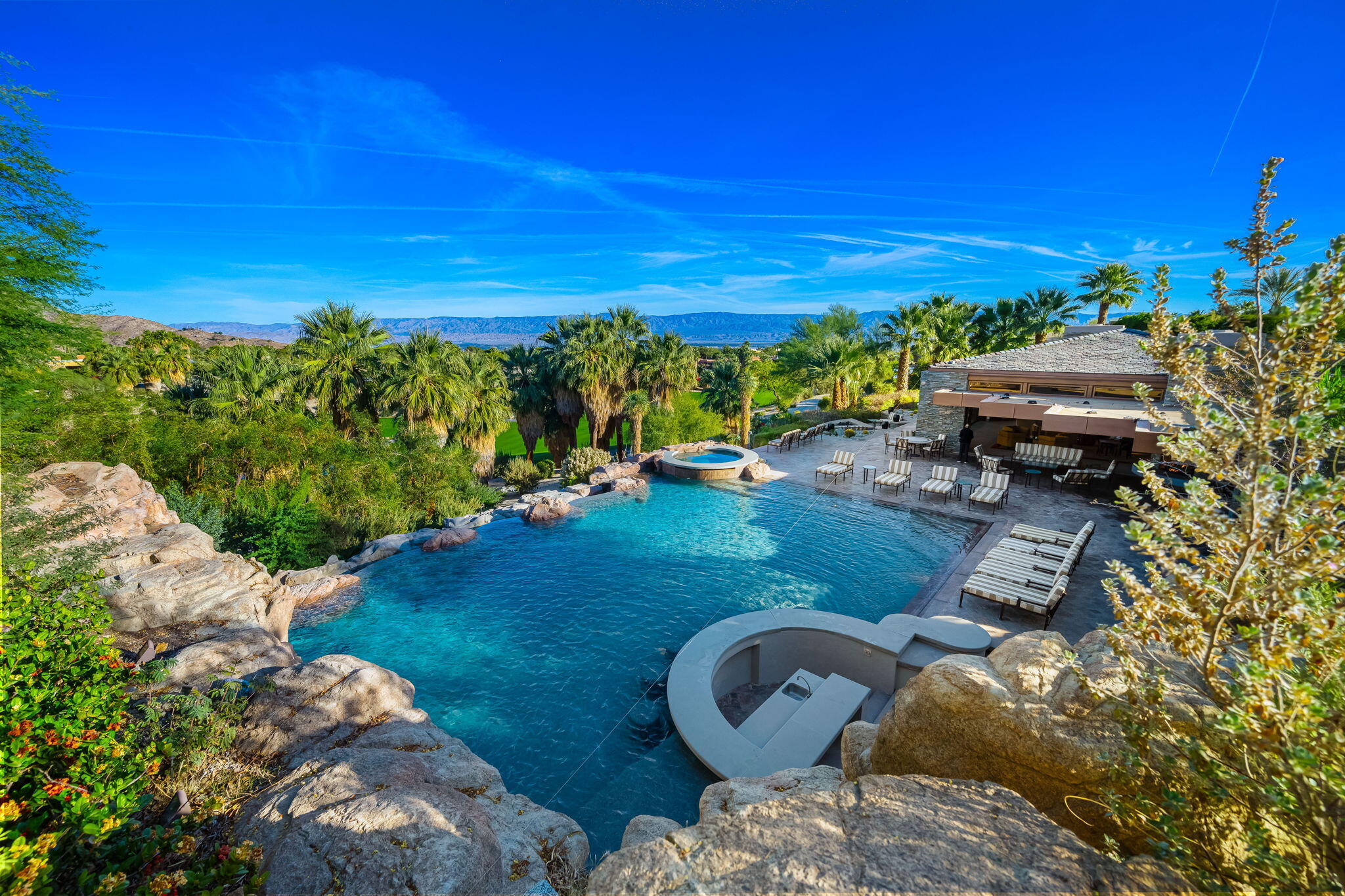 100 Lantana View Palm Desert, CA 92260 - Photo 85 of 121 a view of a swimming pool with lawn chairs under an umbrella