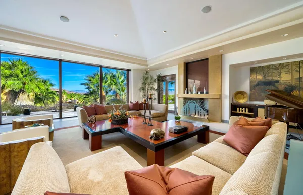 a living room with dining room and large windows